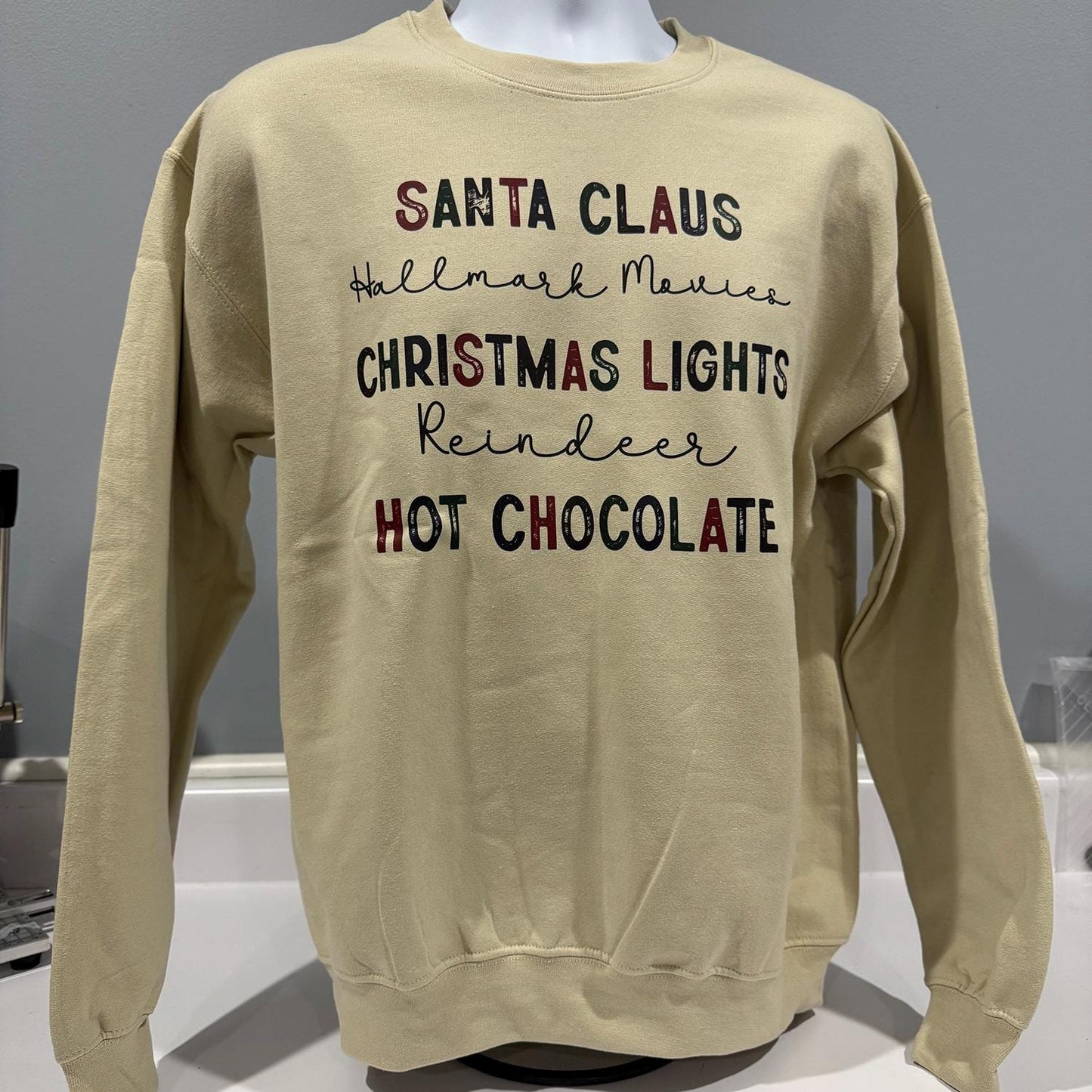 Santa Claus, Hallmark Movies, Christmas Lights, Reindeer & Hot Chocolate” Sweatshirt
